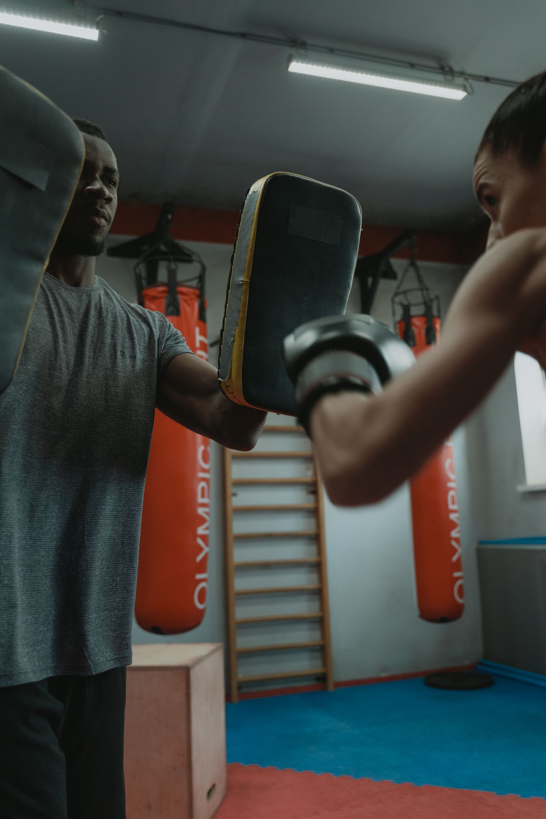 Boxerin beim individuellen Pratzentraining mit einem Personal Trainer.