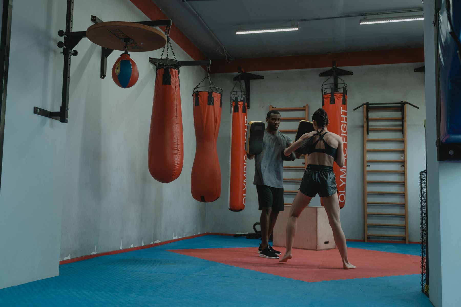Boxer und Trainer bei einer konzentrierten Einheit mit Pratzen.
